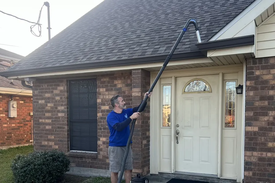 Darin of Vivid Window Cleaning cleaning gutters with a gutter vacuum