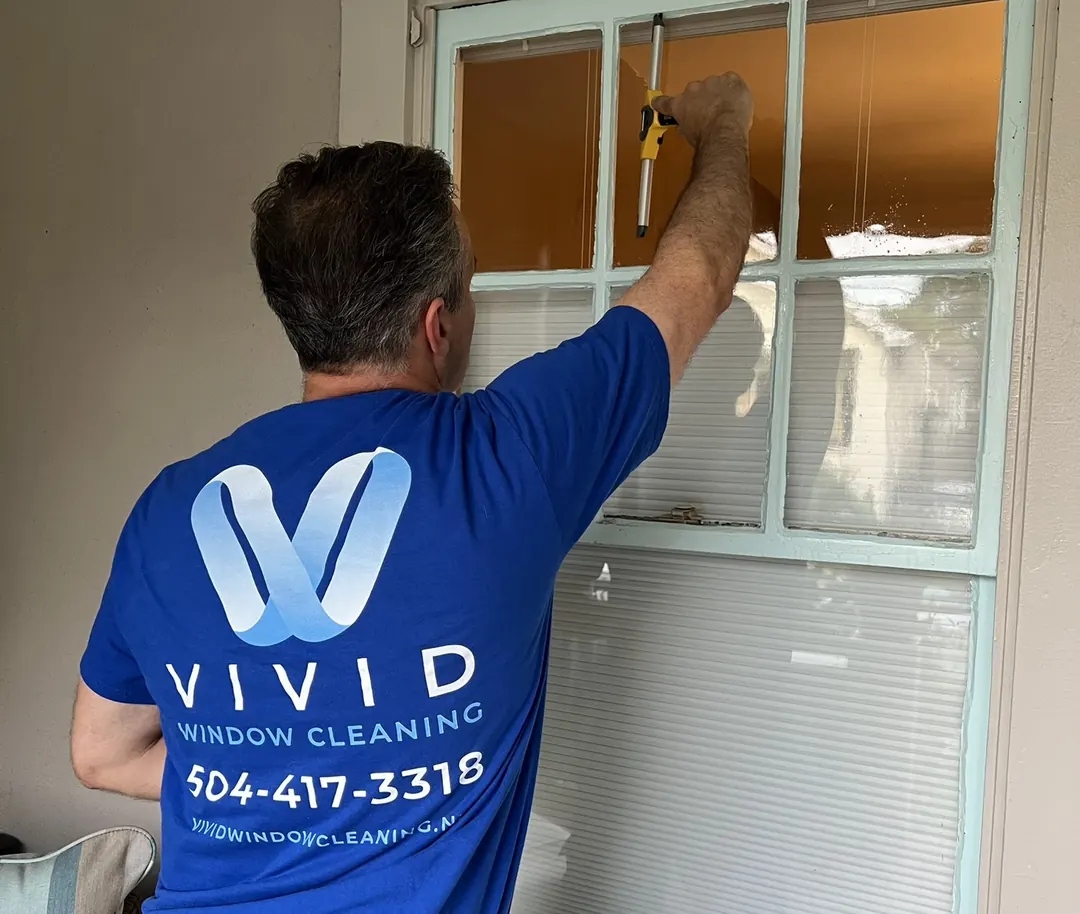 Darin of Vivid Window Cleaning cleaning a residential window with a squeegee