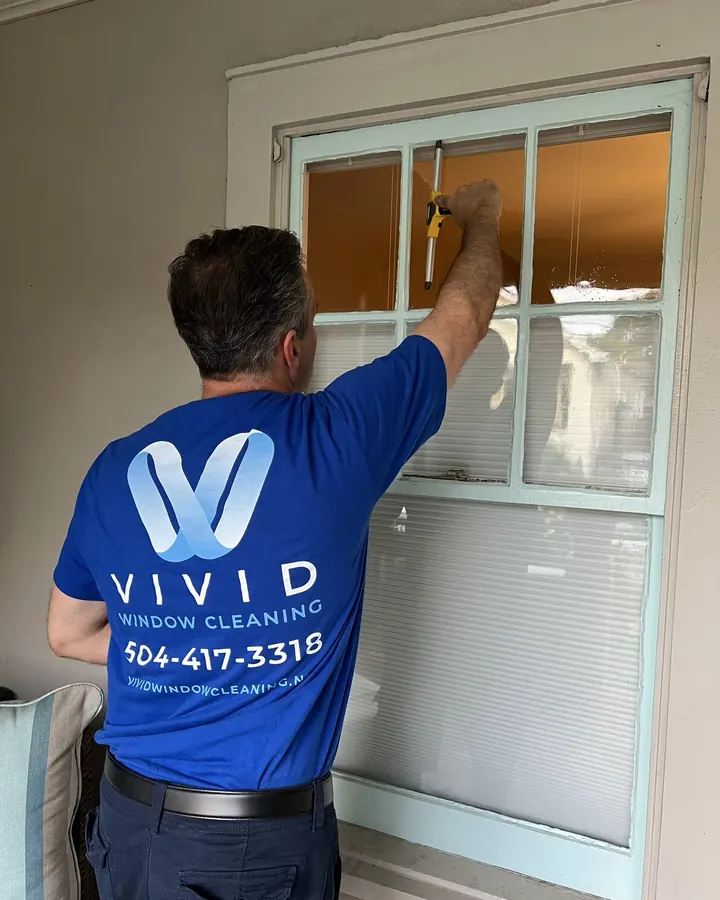 Darin of Vivid Window Cleaning cleaning a residential window with a squeegee